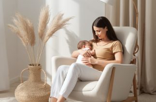 Mulher amamentando recém-nascido em casa representando dificuldades na amamentação