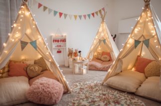 Festa do pijama para crianças com cabaninhas decoradas e luzes aconchegantes