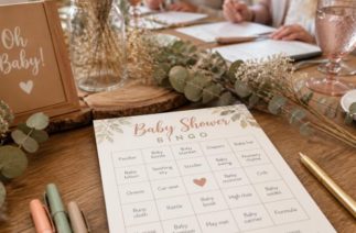 Bingo para chá de bebê com cartelas impressas e canetas organizadas sobre a mesa da festa.