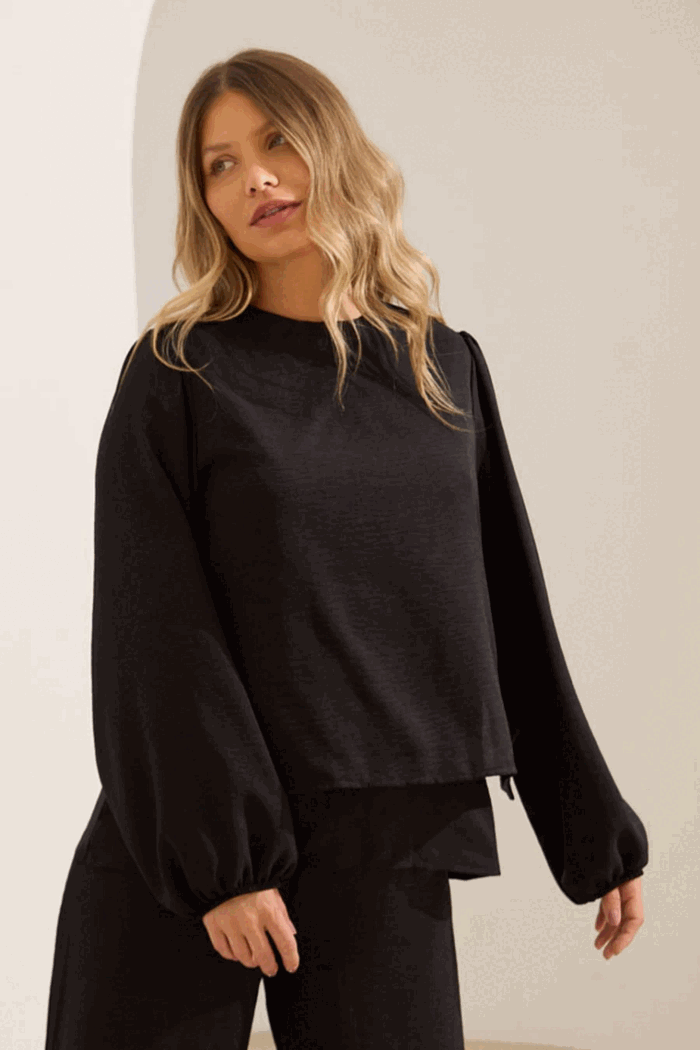 Mulher usando blusa preta de manga longa com dupla camada e abertura para amamentação