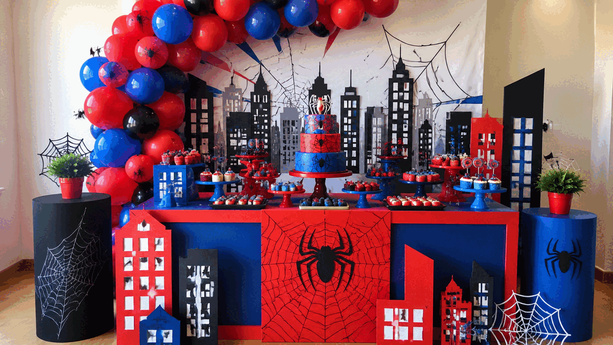 Decoração de festa do Homem-Aranha com balões, painel de cidade, teias, bolo e doces