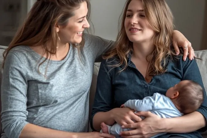 Depressão pós-parto: mãe recebe apoio emocional durante o pós-parto enquanto segura o bebê no colo